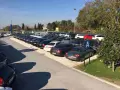 Parcheggio con auto moderne, forse vicino a Venezia Mestre o Santa Lucia. Un cartello blu con la "A" indica un'area di sosta.