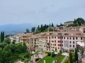 Asolo, cosa vedere: un borgo collinare con case in pietra, tetti rossi e giardini lussureggianti, incastonato tra le montagne.