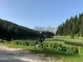 Ciclista ammira il panorama sul lago e le montagne lungo la ciclabile Auronzo Misurina.