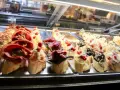 Assortimento di cicchetti in una vetrina di un'osteria veneziana: crostini con salumi, pesce e verdure.