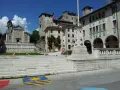 Piazza con scalinata, chiesa e castello: ecco cosa vedere a Feltre. Stendardi gialli decorano gli edifici storici.