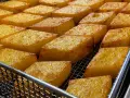 Dorati e croccanti cubetti di crema fritta, un classico di Chioggia, pronti per essere gustati.