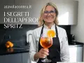 Donna sorridente con un bicchiere di Spritz, pronta a svelare i segreti delle giuste dosi per spritz perfetti.