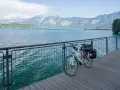 Bicicletta da turismo pronta per esplorare le ciclabili Dolomiti, con un lago azzurro e montagne maestose sullo sfondo.