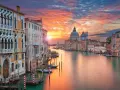 Tramonto sul Canal Grande, un quadro perfetto di posti romantici a Venezia. Palazzi storici e la Basilica di Santa Maria della Salute riflettono i colori del cielo.