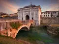 Porta San Tomaso a Treviso, un'idea per cosa fare a Treviso nel weekend. Un ponte in mattoni attraversa un canale con acqua verde.