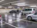 Parcheggio sotterraneo con diverse auto, tra cui un furgone bianco e una berlina nera. Un'auto argentata è in primo piano. Questo è l'ingresso a Venezia per chi arriva in auto.