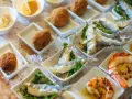 Assaggio di prodotti tipici veneziani: crocchette dorate, sarde fritte e gamberi grigliati, presentati su un letto di ghiaccio.