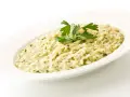 Risotto cremoso con prezzemolo, un piatto che evoca i sapori del mare di Venezia.