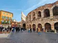 L'arena di Verona interno, con la sua maestosa struttura in pietra e archi, fa da sfondo a una piazza animata da turisti.
