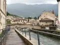 Passeggiata lungo il canale, tra antichi palazzi e ponti in pietra. Ecco cosa vedere a Vittorio Veneto, con le montagne sullo sfondo.