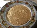 Un cremoso risotto di go Burano, servito in un piatto decorato con le case colorate dell'isola.