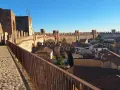 Passeggiata sulle mura della **cittadella** di Padova, con vista sui tetti e le torri medievali sotto un cielo azzurro.