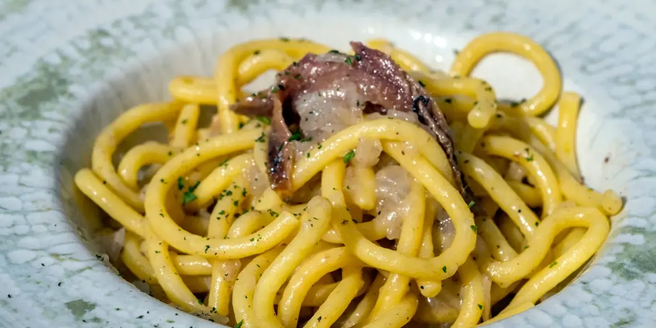 Spaghetti con acciughe e prezzemolo, un assaggio di cosa si mangia a Venezia. Un piatto semplice ma gustoso, perfetto per un pranzo veloce.
