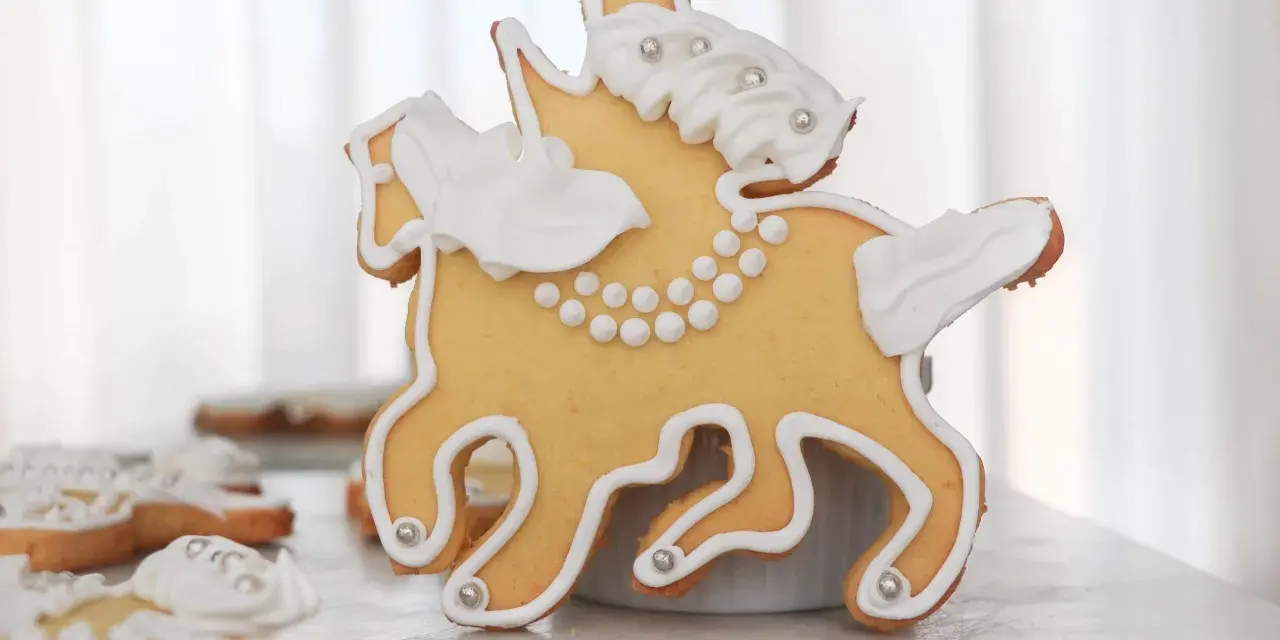 Biscotti a forma di cavallo decorati con glassa bianca e perline argentate, un dolce San Martino che racconta una storia.