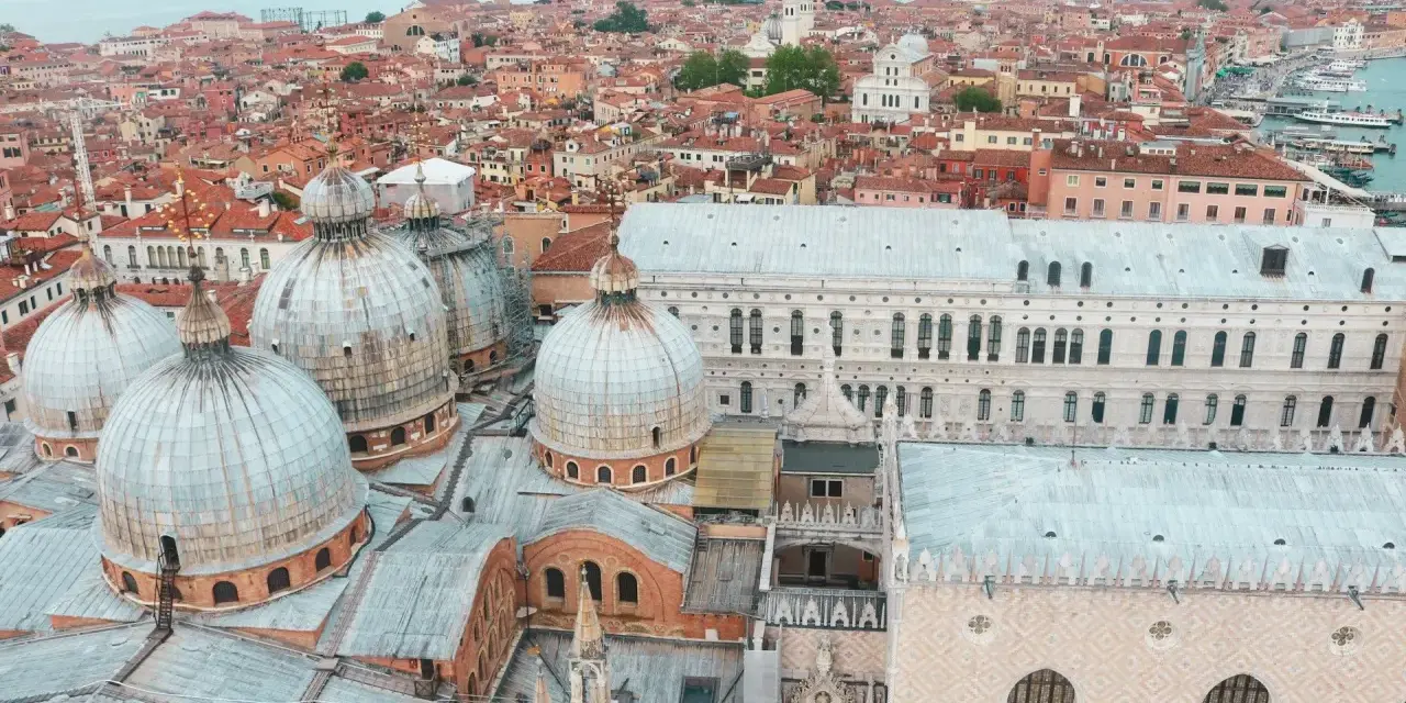 Vista aerea di Venezia con cupole imponenti e tetti rossi, un panorama mozzafiato della città sull'acqua.