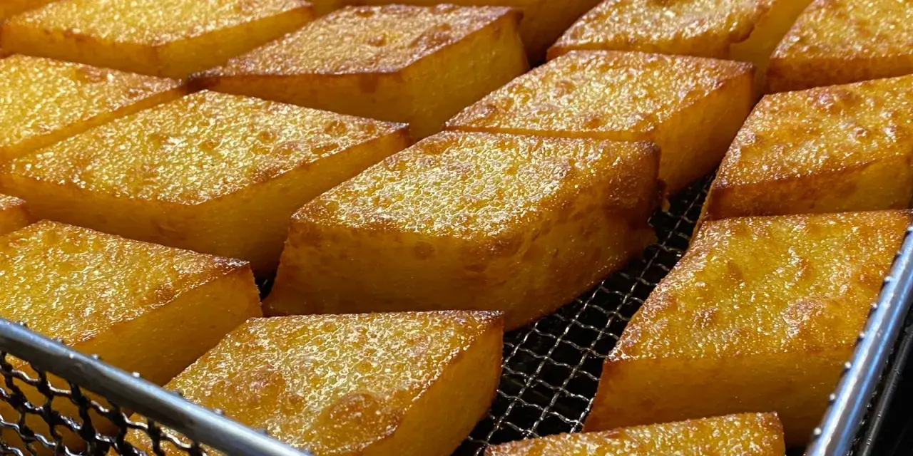 Dorati e croccanti cubetti di crema fritta, un classico di Chioggia, pronti per essere gustati.