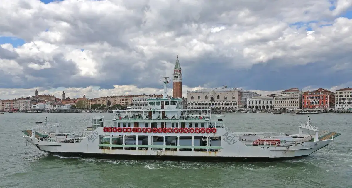 Traghetto ACTV che naviga sul Canal Grande, con lo sfondo di Venezia e il Palazzo Ducale.