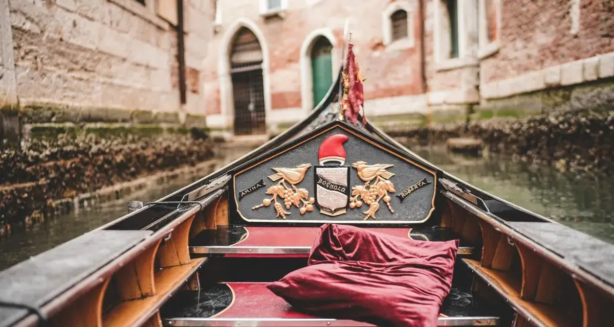 Gondola con cuscino rosso, pronta per un giro romantico a Venezia, città dell'amore.
