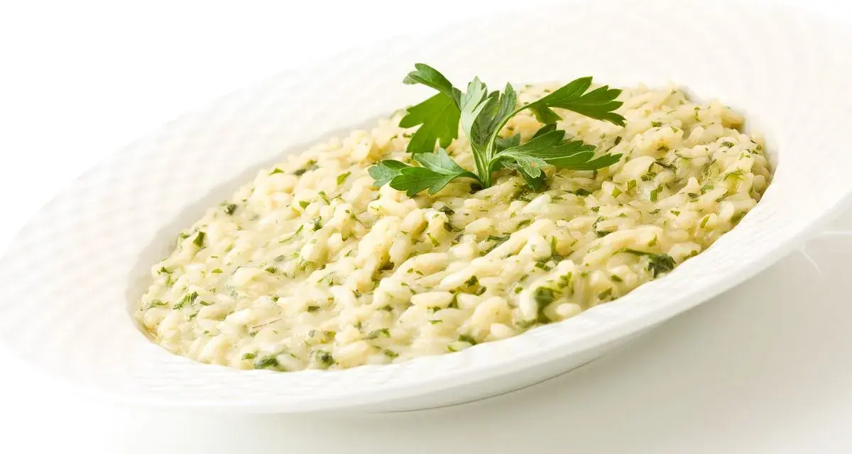 Risotto cremoso con prezzemolo, un piatto che evoca i sapori del mare di Venezia.