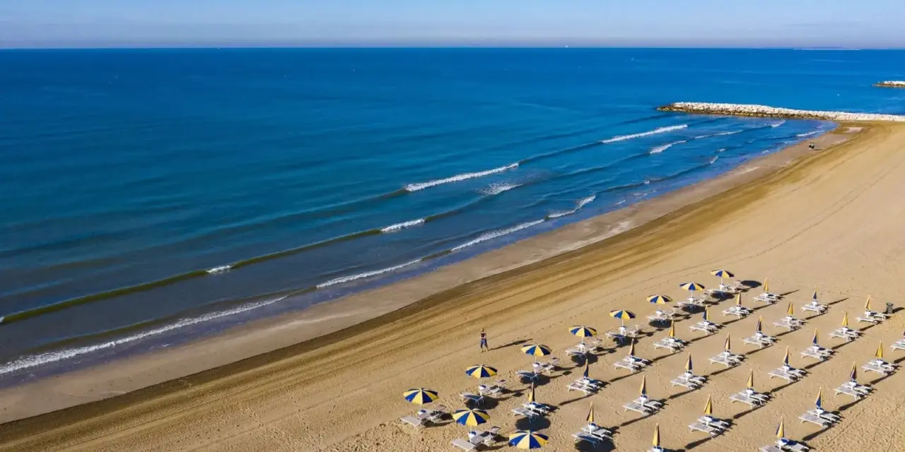 Spiaggia di Cavallino-Treporti con ombrelloni e lettini pronti per l'estate. Scopri come arrivare in questo paradiso!