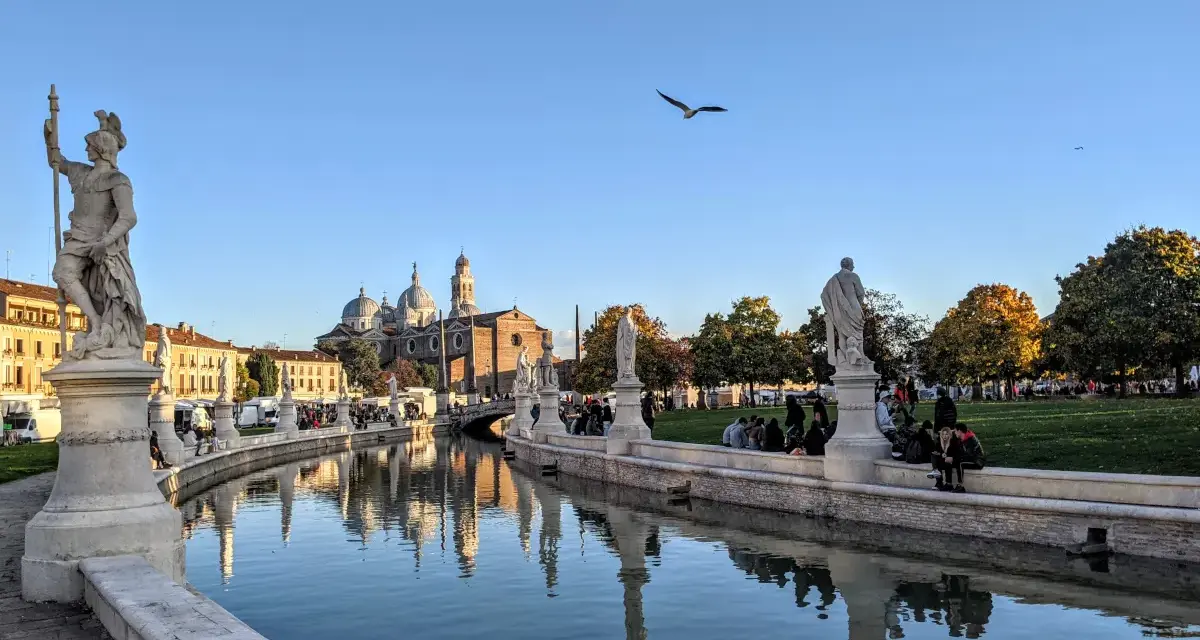 Statue e canale a Padova, con la Basilica di Sant'Antonio sullo sfondo. Ideale per capire quanti giorni per visitare Padova.
