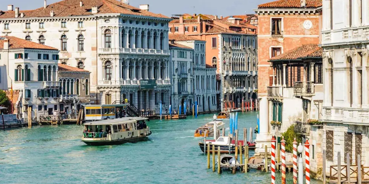 Vaporetti sul Canal Grande, un modo efficiente per il pagamento dei trasporti a Venezia. Palazzi storici e acqua turchese.