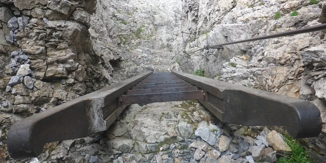 Scalinata in metallo e legno su roccia, parte di un percorso attrezzato, tipico delle ferrate in Veneto.
