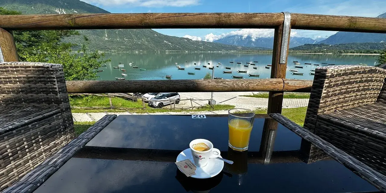 Un caffè e un succo d'arancia con vista sul lago di Santa Croce, ideale per un momento di relax e per decidere dove mangiare.