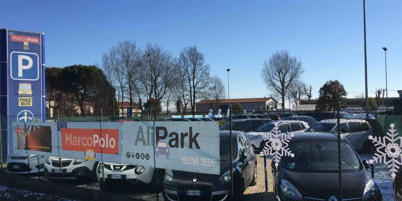 Parcheggio all'aeroporto di Venezia Marco Polo con cartelli informativi e auto in sosta.