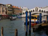 Venice canal with gondola, Rialto Bridge, and buildings.