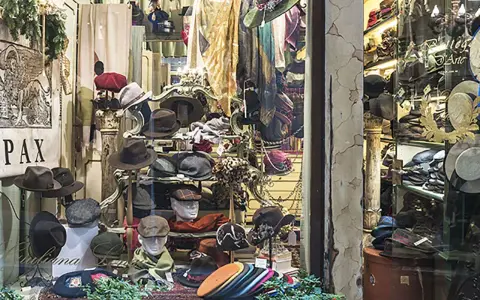 Vetrina di negozi Venezia con cappelli eleganti e sciarpe colorate, un'esplosione di stile per ogni occasione.