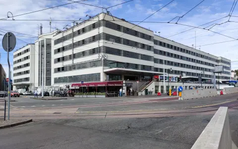 Edificio moderno con finestre a griglia, ideale per chi cerca dove parcheggiare a Venezia. Si intravedono locali commerciali e traffico.