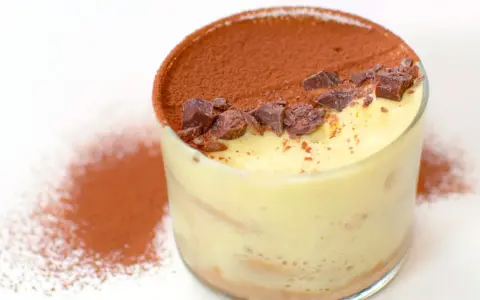 Un bicchiere di tiramisù, con cacao e scaglie di cioccolato. Ecco come si fa il tiramisù, un dolce al cucchiaio irresistibile.