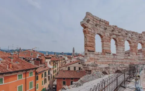 Resti antichi dell'Arena di Verona, testimoni di quanti anni ha l'Arena di Verona, si stagliano su un panorama di tetti rossi.