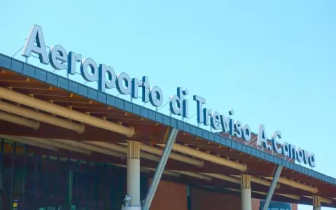 Aeroporto di Treviso A. Canova, uno dei principali aeroporti del Veneto, con insegna luminosa sotto un cielo azzurro.