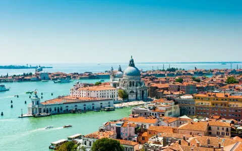 Venezia, con la sua Basilica di Santa Maria della Salute e i canali vibranti, offre infinite curiosità. Le case colorate e i tetti rossi si specchiano sull'acqua.