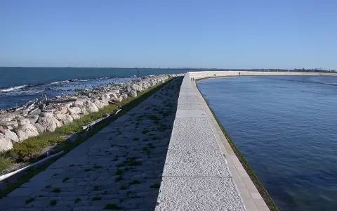 Passeggiata sul molo che porta alla spiaggia Ca' Roman. Come arrivare: segui il sentiero lastricato lungo il mare.