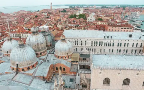 Vista aerea di Venezia con cupole imponenti e tetti rossi, un panorama mozzafiato della città sull'acqua.