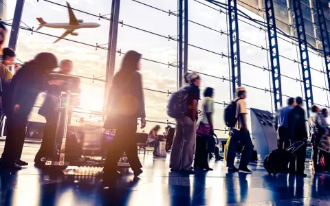 Persone in un aeroporto con un aereo in volo fuori dalla finestra. Probabilmente l'aeroporto più vicino a Venezia.