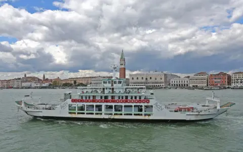 Traghetto ACTV che naviga sul Canal Grande, con lo sfondo di Venezia e il Palazzo Ducale.