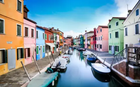 Case colorate lungo un canale a Burano, dove le case sono costruite su palafitte, un'ingegnosa soluzione per capire su cosa è costruita Venezia.