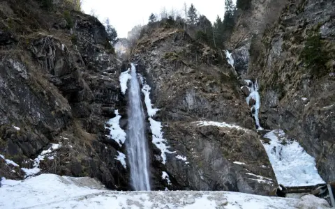 Cascate in Veneto, con rocce innevate e ghiaccio che scende lungo i fianchi della montagna.