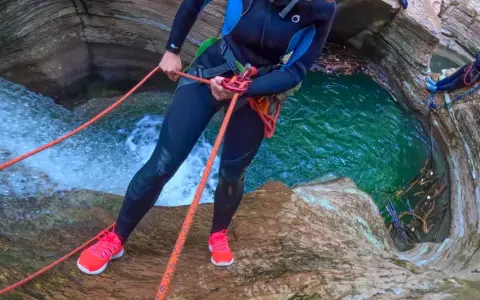 Avventura di canyoning nelle Dolomiti: un'emozionante discesa in corda tra cascate e pozze d'acqua cristallina.