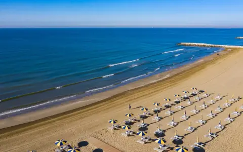 Spiaggia di Cavallino-Treporti con ombrelloni e lettini pronti per l'estate. Scopri come arrivare in questo paradiso!
