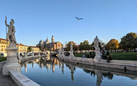 Statue e canale a Padova, con la Basilica di Sant'Antonio sullo sfondo. Ideale per capire quanti giorni per visitare Padova.