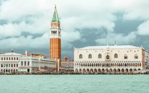 Venezia: Palazzo Ducale, Campanile e il ponte dei sospiri prigione, con gondole sull'acqua.