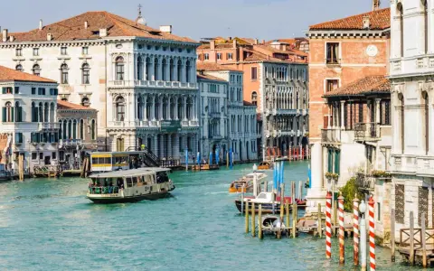 Vaporetti sul Canal Grande, un modo efficiente per il pagamento dei trasporti a Venezia. Palazzi storici e acqua turchese.