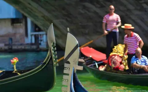 Gondolieri in Venezia, con le loro gondole, navigano sui canali. Chissà quanto guadagna un gondoliere per questa magica esperienza.