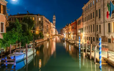 Una gondola venezia di notte, con luci soffuse che si riflettono sull'acqua e un cielo stellato.